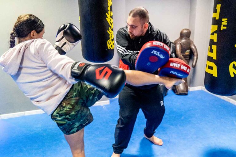 Frau beim Kickbox-Training an den Pratzen