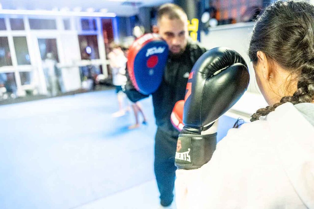 Frau beim Kickbox-Training an den Pratzen